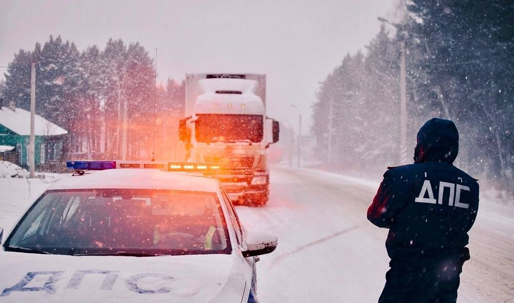 Сотрудники полиции в ручном режиме регулируют движение на федеральной трассе в Иркутской области у границы с Республикой Бурятия